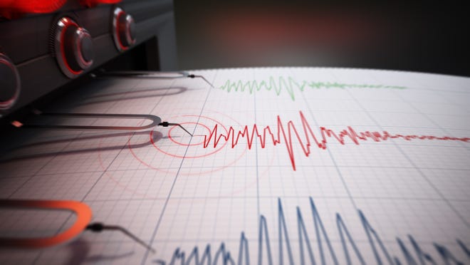 Seismograph printing seismic activity records of an earthquake.