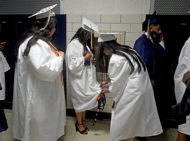 Seaford High School seniors help each other with their gowns before commencement Monday, June 7, 2021, at Bob Dowd Stadium in Seaford, Delaware.