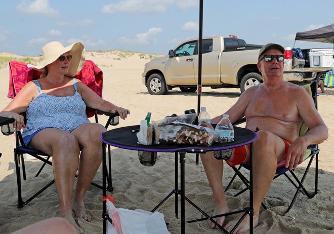Jeri, left, and Dan Nickel relax in the shade as they surf fish Friday, July 16, 2021, on Fenwick Island State Park in Fenwick Island, Delaware.