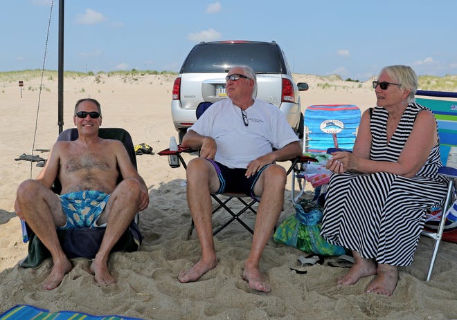 John Bausman, left, Charlie and Cindy Walter, relax in the shade as they wait for a bite surf fishing Friday, July 16, 2021, on Fenwick Island State Park in Fenwick Island, Delaware. The Walter's have a surf fishing permit and are joined by their guests John and Tara Bausman from York, Pennsylvania.