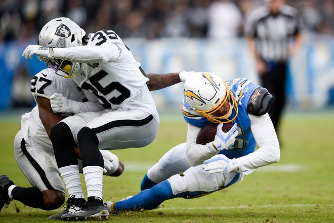 Oakland Raiders free safety Curtis Riley, middle, collides with teammate cornerback Trayvon Mullen while tackling Los Angeles Chargers wide receiver Andre Patton during the second half of an NFL football game Sunday, Dec. 22, 2019, in Carson, Calif. Mullen was hurt on the play. (AP Photo/Kelvin Kuo)